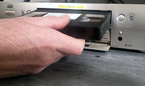 Insertion d'une cassette VHS dans un magnétoscope