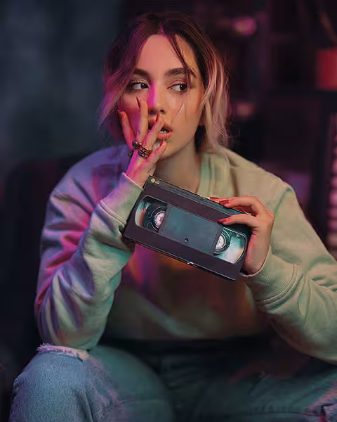 jeune femme dubitative qui tient une cassette VHS